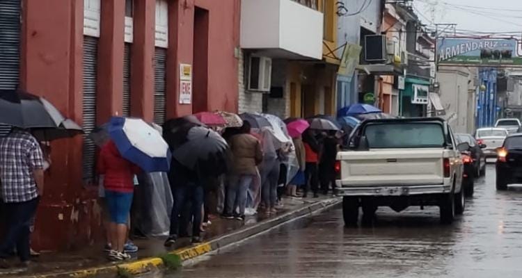 Bono extraordinario de Anses: Bajo la lluvia, siguen las largas colas en los bancos para cobrar
