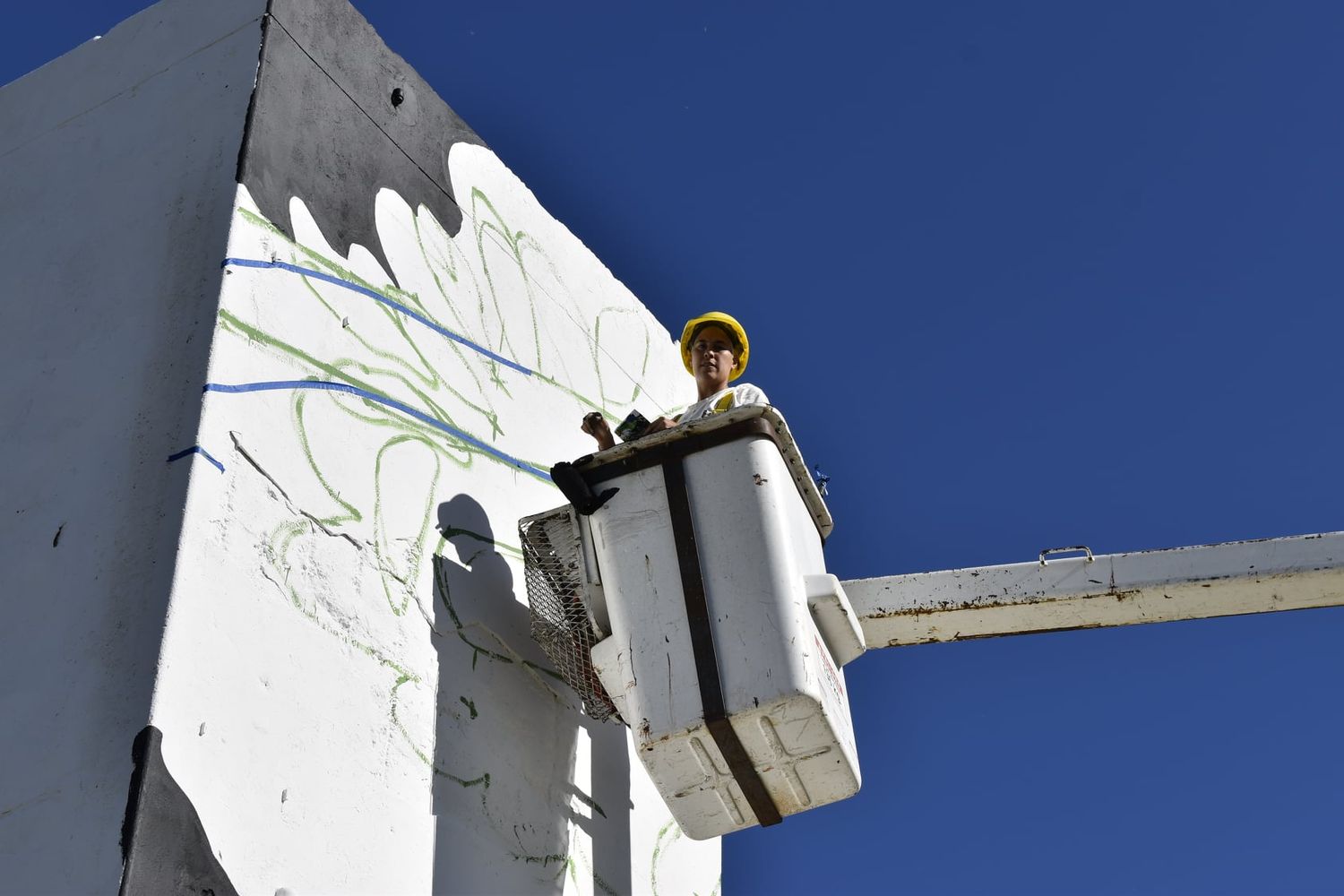 Dana Alessi pinta un mural alusivo al 8M en la torre del exbalneario