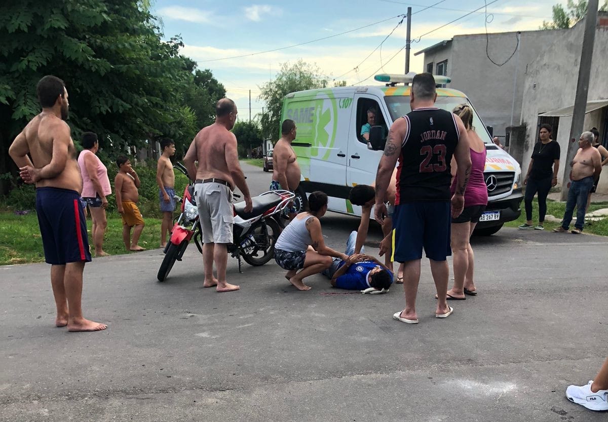 Vecinos asisten a un herido tras el choque de dos motos