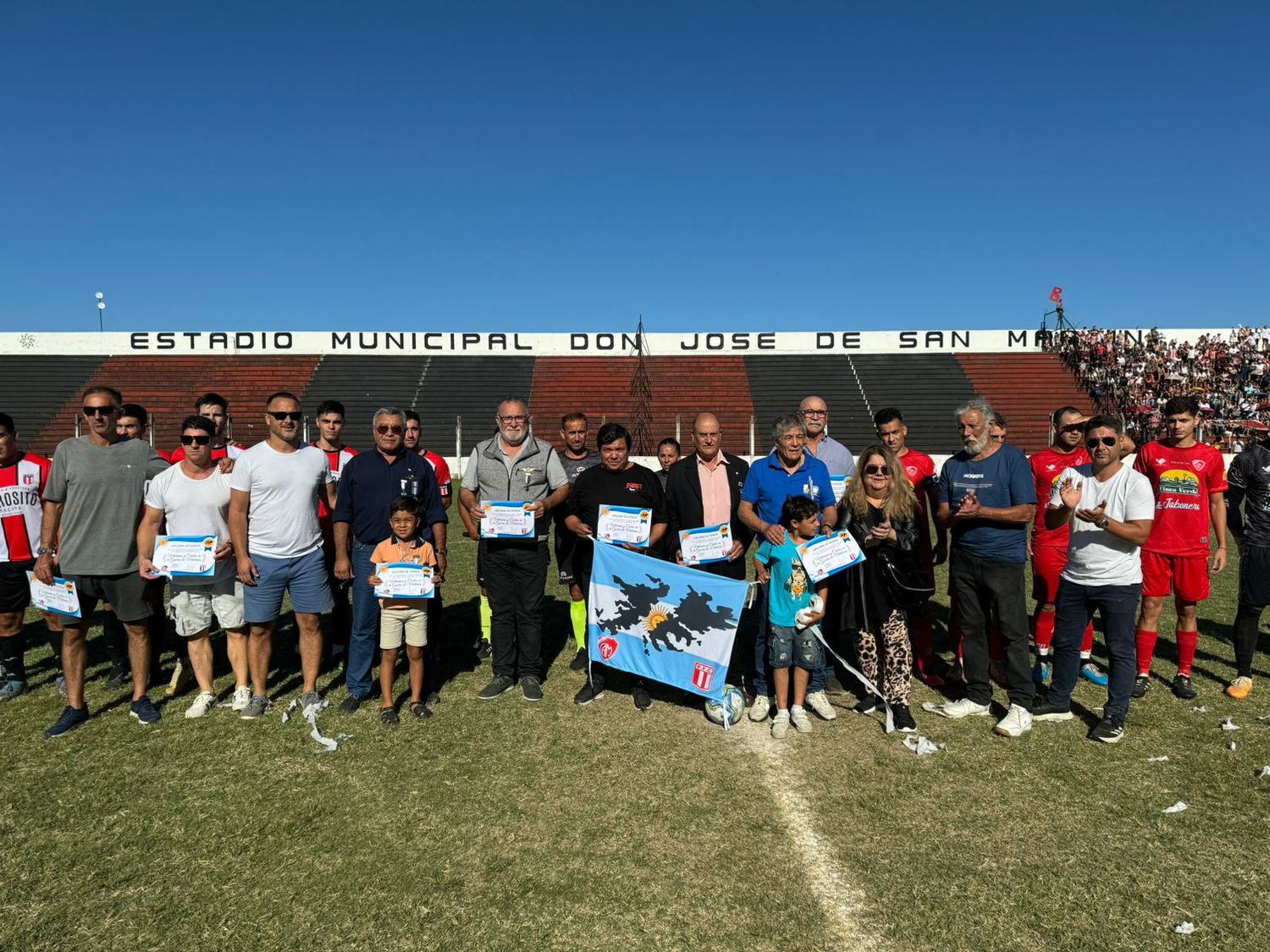 Los equipos de Mitre y Paraná en el homenaje a los ex combatientes antes de comenzar el partido en el Estadio Municipal.